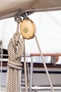 Wooden pulley with rope on a sailboat boom