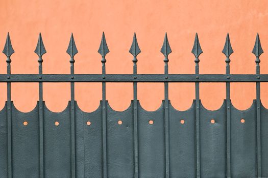 Wrought iron fence with arrow head protecting house