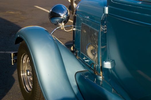 A Classic blue hotrod reflects in the afternon sunlight