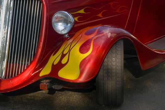 A classic bright red hotrod with flames