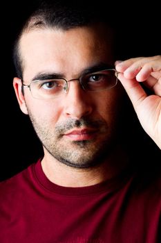 Close detail view of a young male man with glasses isolated on a black background.