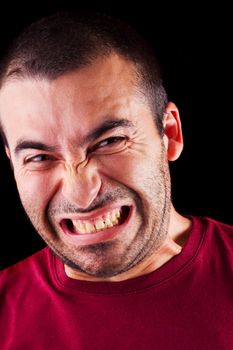 Close detail view of a angry young male man isolated on a black background.