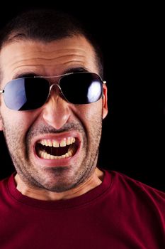 Close detail view of a funny scared young male man isolated on a black background.