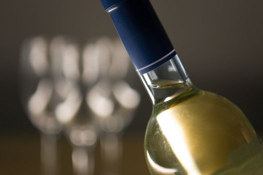 Unopened wine bottle and glasses on a wooden table