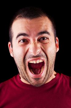 Close detail view of a screaming young male man isolated on a black background.