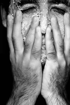 Close up view of a man's hands removing the mask from the face.