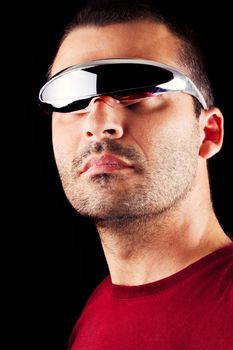 Close detail view of a young male man with futurist glasses isolated on a black background.