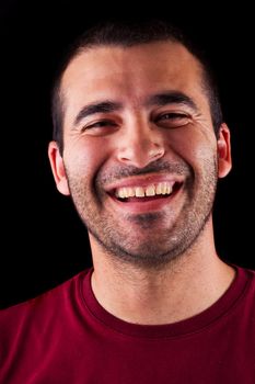 Close detail view of a happy young male man isolated on a black background.