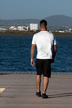 View of a young man walking down the pier.