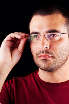 Close detail view of a young male man with glasses isolated on a black background.