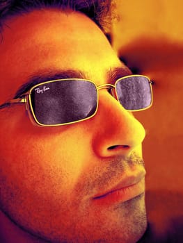 young man face with cool colored face with glasses.