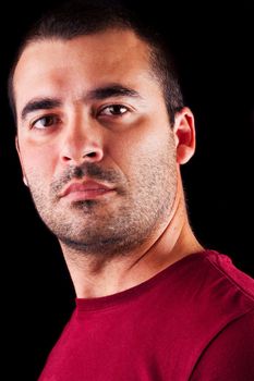 Close detail view of a confident  young male man isolated on a black background.