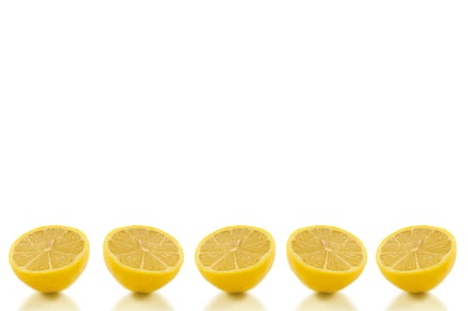 Five small lemon halves arranged in a horizontal row along the bottom of the image and over white.