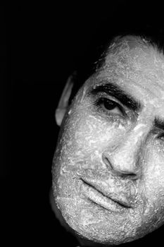 Close up view of a man looking with the face full of flour.