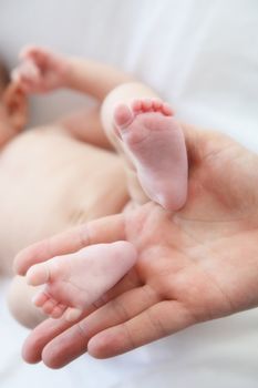 two baby feet are held by a hand-Close-up
