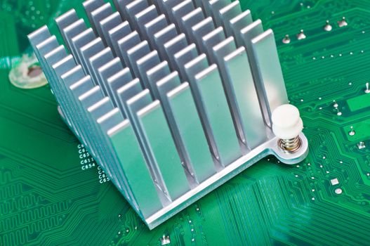 Close-up of an aluminum heatsink mounted on as green computer circuit board