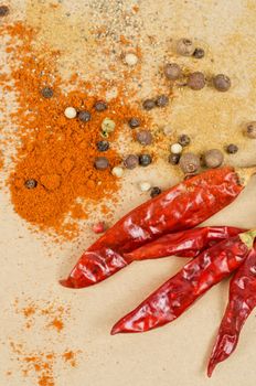 dried peppers and other kind of peppers spices on a brown background
