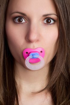 Beautiful young woman sucking pacifier