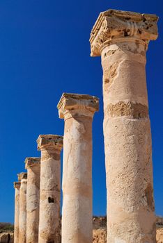 Ancient Greek columns in the ruins against a blue sky.