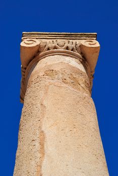 Ancient Greek columns in the ruins against a blue sky.