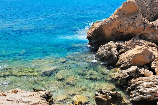 Rocky shore of the Mediterranean sea with clear water.