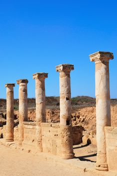 Ancient Greek columns in the ruins against a blue sky.