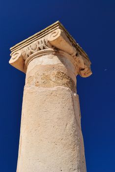 Ancient Greek columns in the ruins against a blue sky.