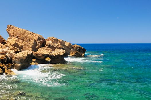 Rocky shore of the Mediterranean sea with clear water.