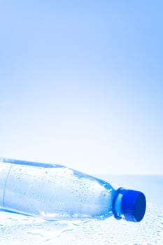 Wet plastic water bottle with water drops