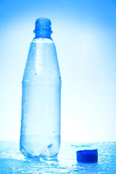Wet plastic water bottle with water drops