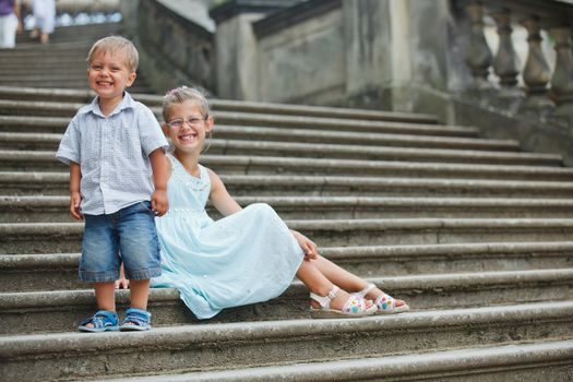 Brother and sister outdoors in city on beautiful summer day