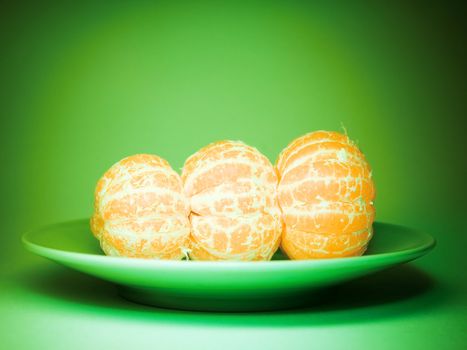 Three tangerines on a plate