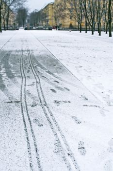 Footprints on snow in winter park while snow storming