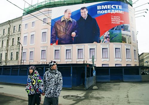 ST PETERSBURG, RUSSIA-MARCH 02, 2008: Citizens pass by banner for presidential election campaign showing President Vladimir Putin and Candidate Dmitri Medvedev. Slogan reads: Together We Will Win