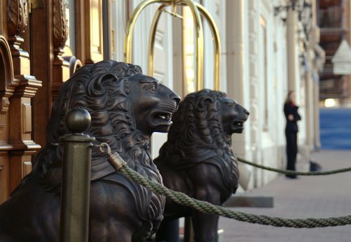 Wooden lion sculptures at the entrance of a hotel.