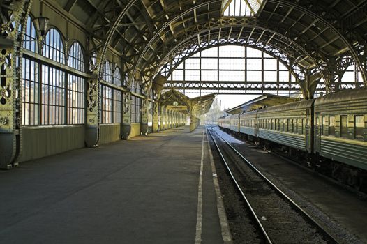 Railroad station platform in Saint Petersburg, Russia, with hanging clocks and "Have a nice trip" signboard.