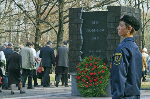 ST PETERSBURG - MAY 5: March in memory of WWII victims in city Victory Park. Schoolboy, 13, in scout uniform on honor guard May 5, 2008 in St Petersburg, Russia. Slogan on monument: We Remember You