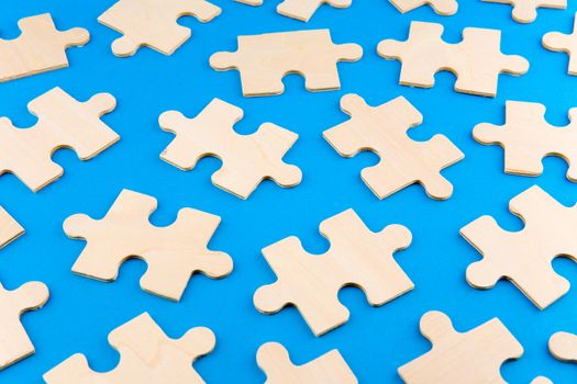 Wooden puzzle pieces on blue background