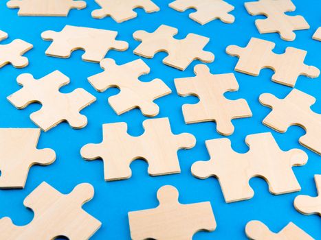 Wooden puzzle pieces on blue background