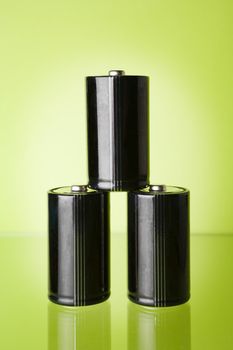 Three batteries on green background