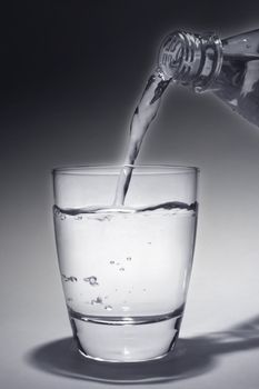 Water pouring from a bottle to a glass