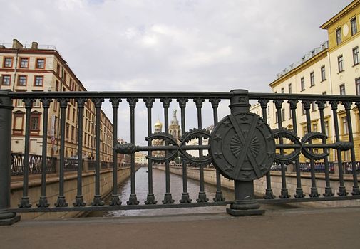 A view from a bridge over Griboyedov\'s Channel in Saint Petersburg, Russia. The Church of the Saviour-on-Blood is seen in the background through the railings.