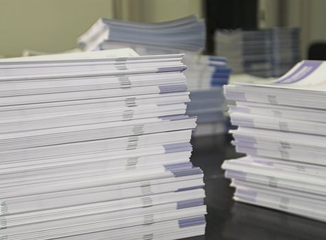 Piles of handout papers lying on a table.