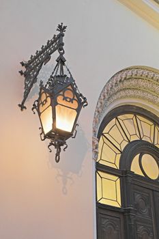 Old lamp on a cathedral's wall at evening. The entrance to the German Evangelic Lutheran Church in Saint Petersburg, Russia.