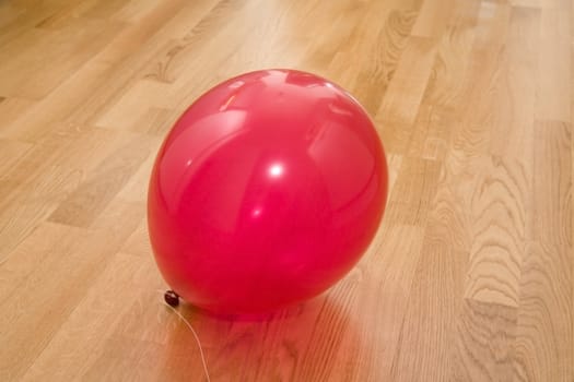 Red balloon on a new parquet floor