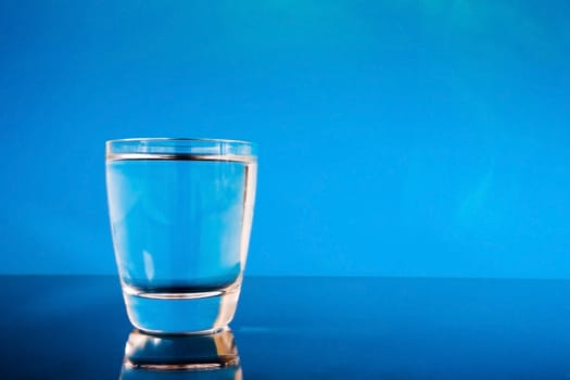 Glass of water on a reflective surface