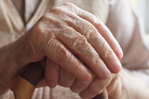 Hand of a senior man holding a cane