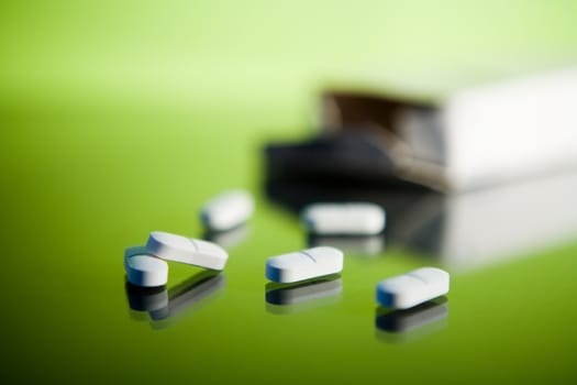 Medical tablets on a reflective glass surface