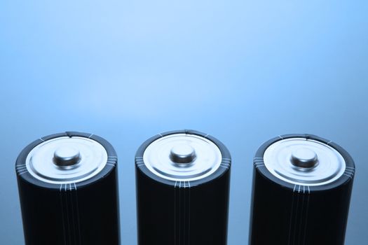 Three LR20 alkaline batteries on a reflective studio background