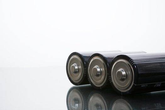 Three LR20 alkaline batteries on a reflective studio background